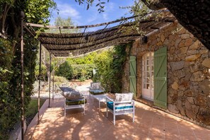 A covered outdoor seating area with stone walls and a pergola. - Superb Villa with Private Pool and Sea Views (Sainte-Maxime)