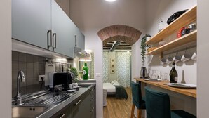 Eine kleine Küche mit modernem Design, ausgestattet mit einem Einbauofen, einem Spülbecken und einer Holz Arbeitsplatte.