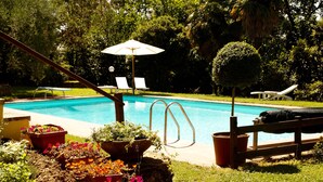 Una piscina con sillas de descanso y una valla de madera.