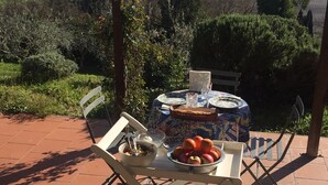 Un patio al aire libre con una mesa lista para comer, rodeado de una vista panorámica de colinas y árboles.