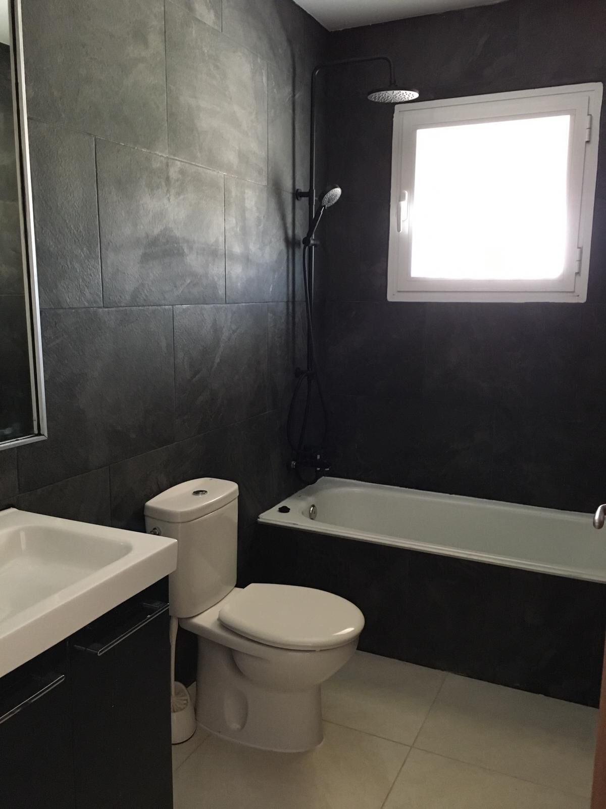 Een badkamer met toilet, wastafel en bad.