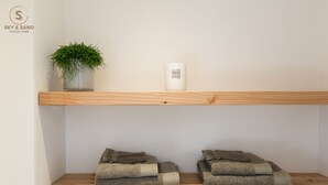 Une étagère avec une plante en pot et une bougie.
