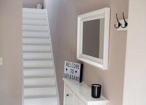 A staircase leading to a room with a sign reading "WELCOME TO SKY & SAND".