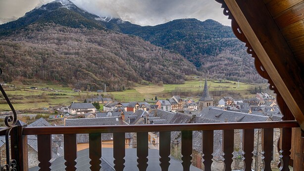 Un balcón con vistas a un pueblo y montañas.