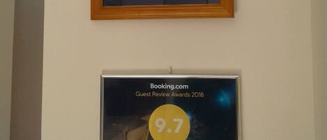 Tres premios enmarcados en una pared: un Certificado de Excelencia 2018 de TripAdvisor, unos premios Traveller Review Awards 2020 con una calificación de 9.8 de Booking.com, y unos premios Guest Review Awards 2018 con una calificación de 9.7 de Booking.com.