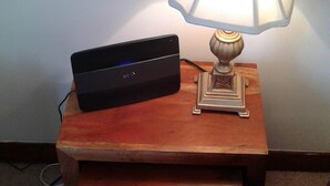 A small wooden nightstand with a lamp and a black electronic device on top. - Tranquil Retreat, Two Bedrooms, Two Bathrooms (one en-suite, one shower room) (Hastings)