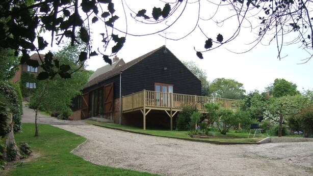 A house with a gravel driveway, a wooden deck, and a garden area. - Tranquil Retreat, Two Bedrooms, Two Bathrooms (one en-suite, one shower room) (Hastings)