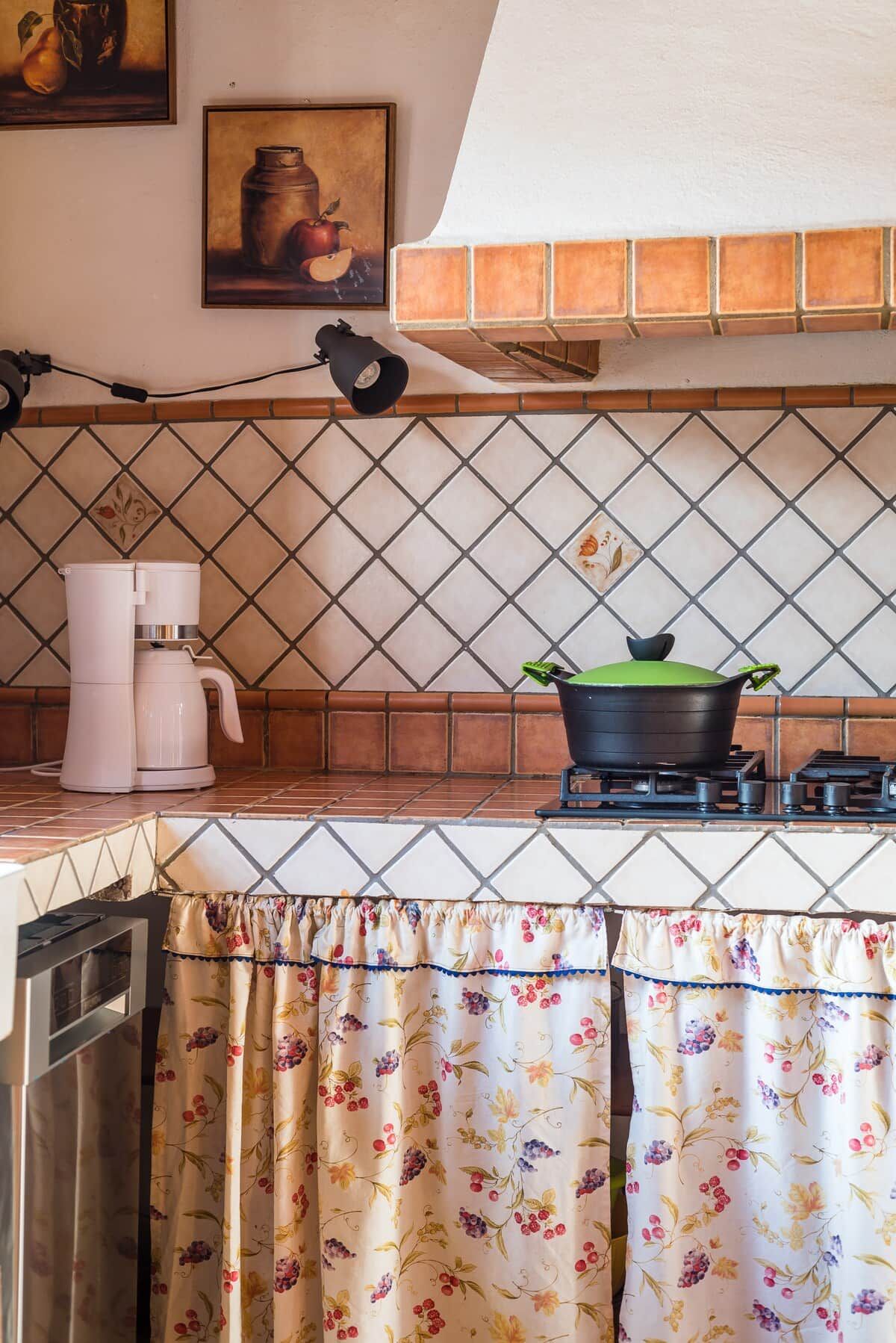 Una cocina con estufa a gas, cafetera y una olla sobre la hornilla.