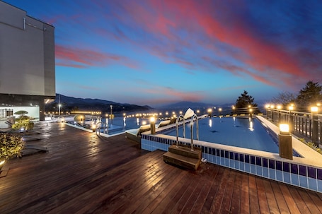 Una piscina al aire libre de temporada, sombrillas