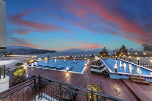 Una piscina al aire libre de temporada, sombrillas