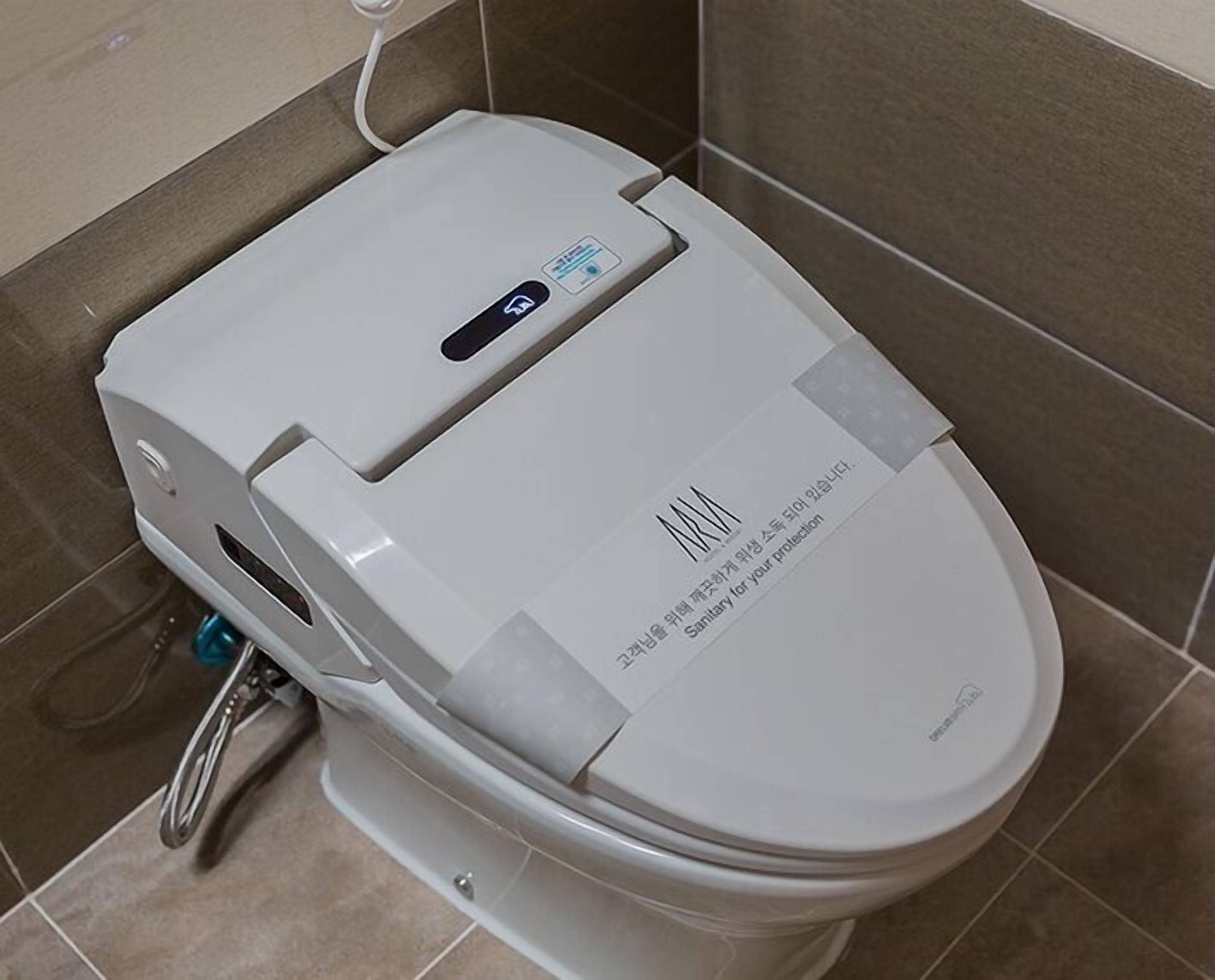 A modern toilet with a digital interface and a water-saving label.