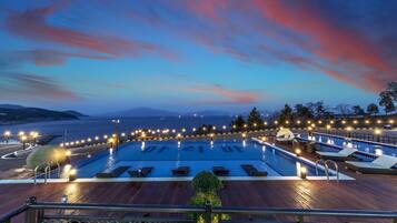 Una piscina al aire libre de temporada, sombrillas