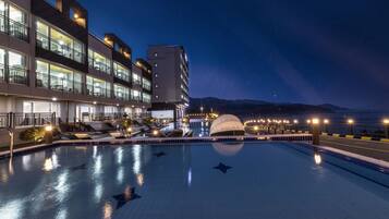 Relax by the rooftop pool surrounded by a paved walkway and a covered seating area with a dome.