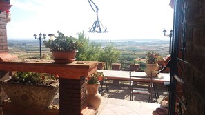 A terrace with potted plants, a brick table, and a view of the countryside. - Sardinia Panoramic Villa oasis relax private swimming pool. LAST MINUTE May-June (Maracalagonis)