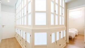 Ein Zimmer mit einem großen Fenster und einem Bett sowie einer Tür.