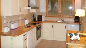 A compact kitchen with white cabinets, a microwave, a toaster, and a sink.