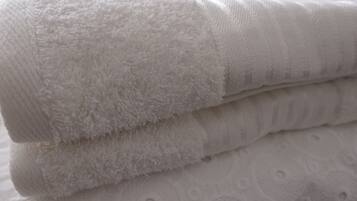 A stack of white towels with different textures and patterns.
