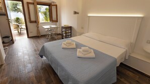 Un dormitorio con cama, dos toallas, una mesita y una silla.