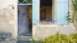 A rustic building with a wooden door and a window with blue shutters. A number '5' is visible on the wall. - Cottage and private garden - rural bliss for two (or 4 with mezzanine) (Corsaint)