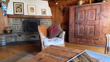 A cozy room with a fireplace, wooden furniture, and a book on a table.