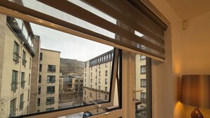 Blick aus einem Fenster eines mehrstöckigen Gebäudes mit Glastür und einer Lampe rechts.