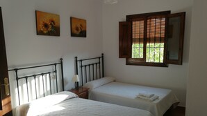 Ein Zimmer mit zwei Betten, einem Nachttisch, einer Lampe und zwei Bildern an der Wand.