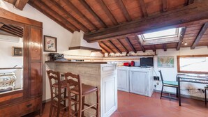 A kitchen with wooden beams, a skylight, and a rustic design.