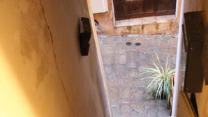 A staircase leading to an outdoor area with a stone floor and a potted plant. - studio - Bonifacio (Bonifacio)