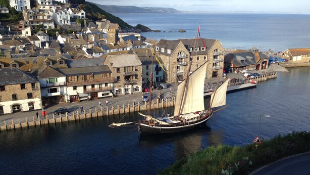 A coastal town with historic buildings, a narrow waterway, and a sailing ship docked at the pier. - Lovely Flat In West Looe With Spectacular Sea & Harbour Views - Non Smokers Only (Looe)