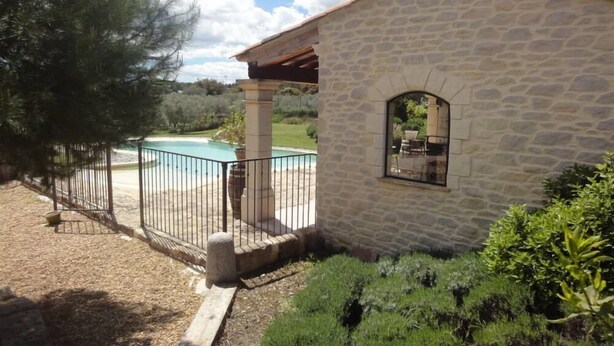 Un edificio de piedra con piscina y vistas del paisaje circundante.