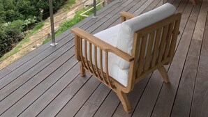 A wooden deck with two white cushioned chairs, overlooking a coastal landscape with a view of the sea and distant hills. - Villa with breathtaking views of Pinarello bay and beach (Zonza)