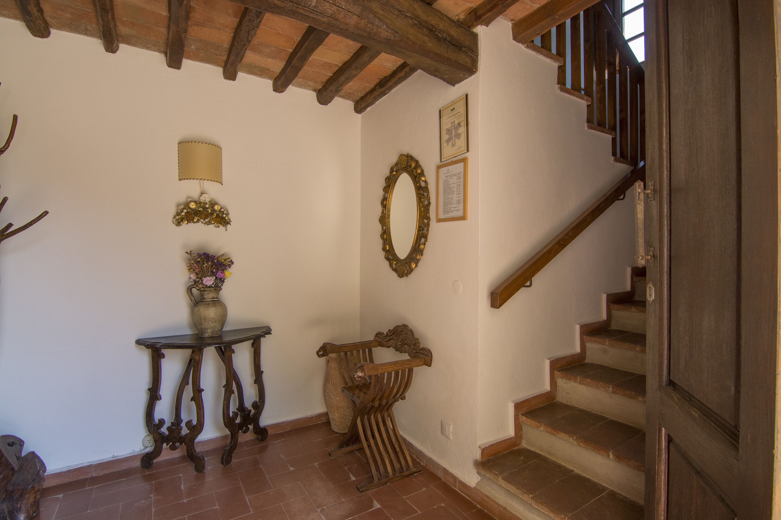 Eine Treppe mit Holzstufen und einem Holgitter, die zu einer oberen Etage führt.