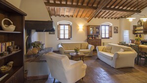 A cozy living room with a high wooden ceiling, a fireplace, and a dining area with a table and chairs. - Chianti villa, with private swimming pool! Air conditioning, ULTRA-FAST Wi-Fi (Greve in Chianti)