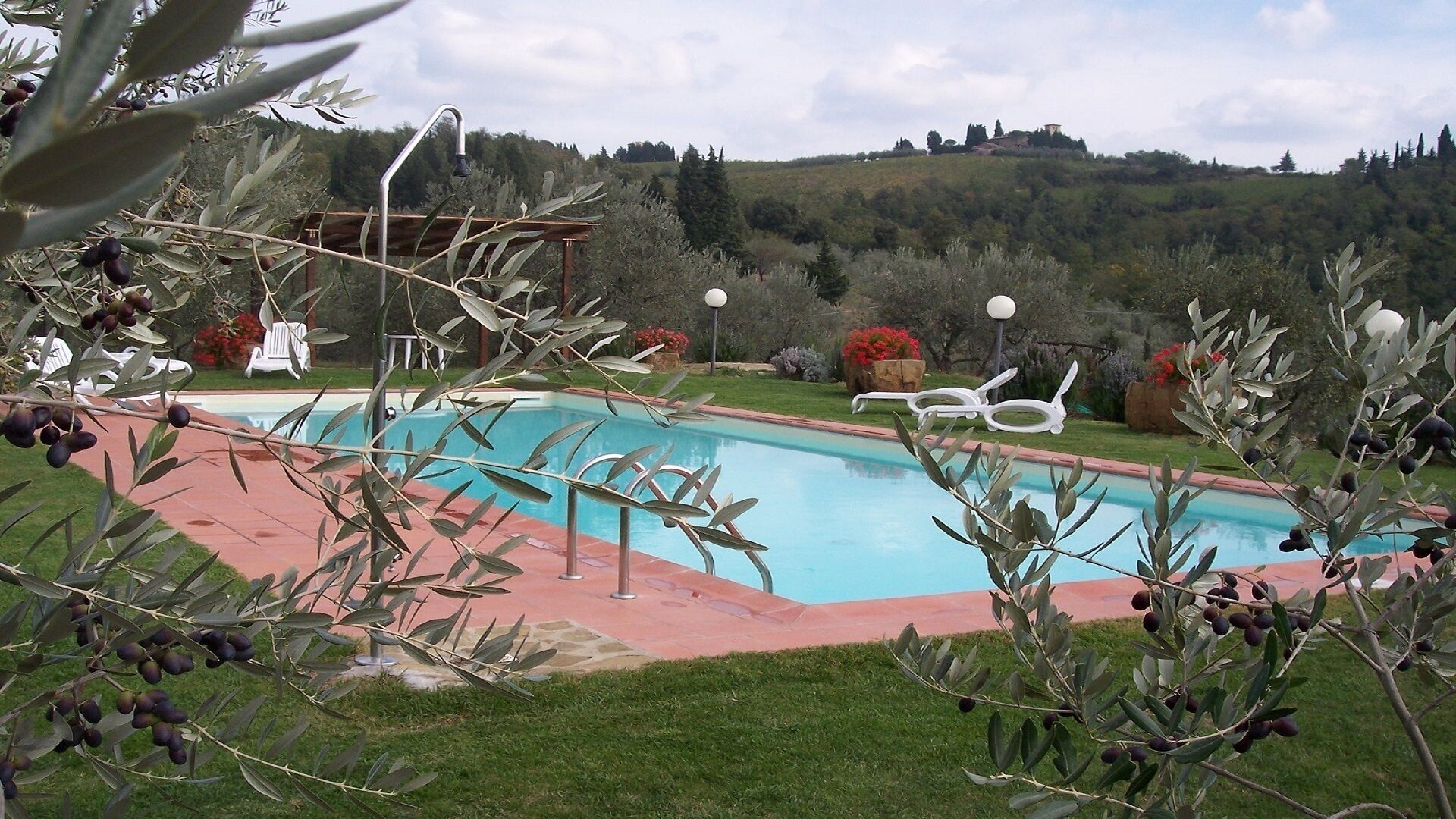 A swimming pool with a view of hills and trees in the background.