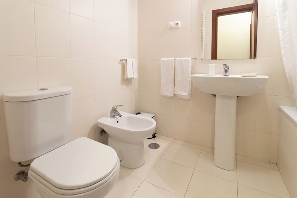 A bathroom with a toilet, bidet, sink, and mirror. - Bento Novo | Historic Manor House Near the Coast, Stunning Gardens (Viana do Castelo)