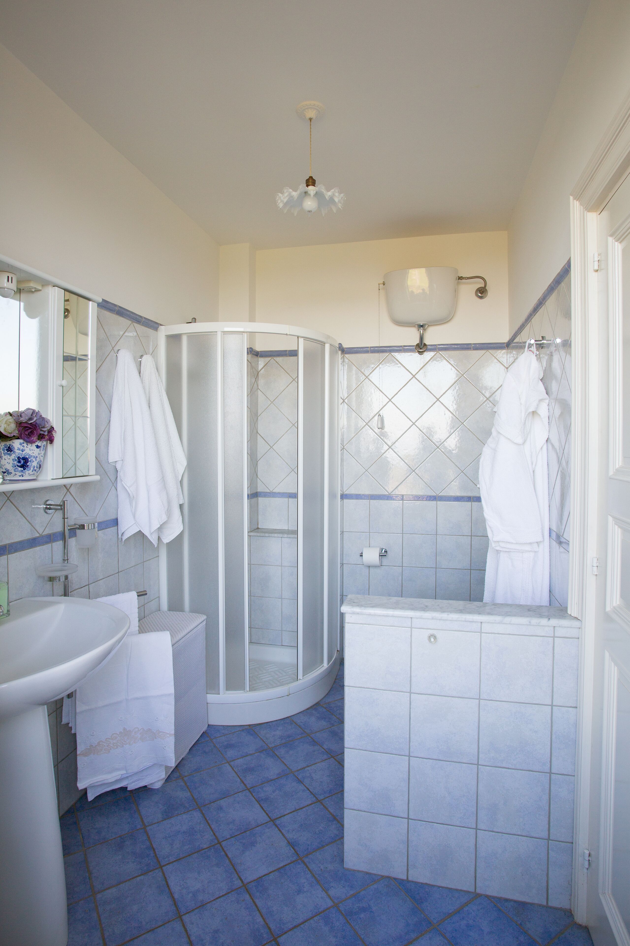 A bathroom with a white sink, a glass shower enclosure, and a white toilet.