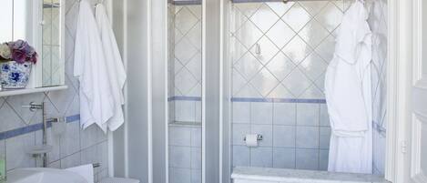 A bathroom with a white sink, a glass shower enclosure, and a white toilet.