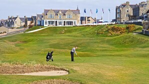 Un terrain de golf avec un club-house en arrière-plan.