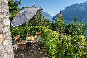An outdoor dining area with a table, chairs, and an umbrella.