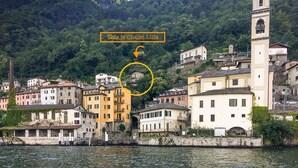 Un pueblo costero con edificios históricos, una imponente torre campanario y un edificio destacado llamado "Pia is Chalet Lilia".