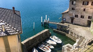 Un puerto con barcos amarrados, un puente y un edificio de fachada de piedra.