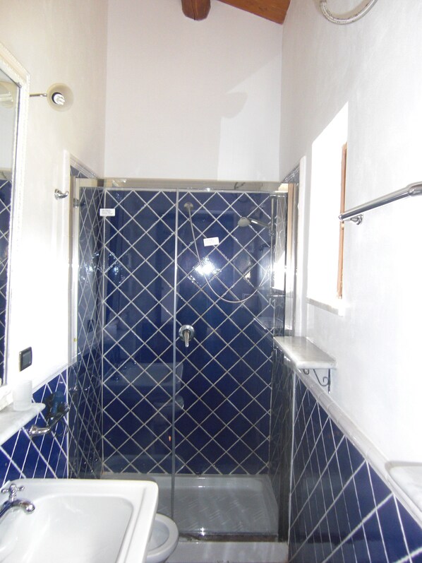A bathroom with a shower, a sink, and a toilet.