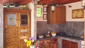 A kitchen with wooden cabinets, a marble countertop, and a bowl of lemons. - Very nice villa with pool with stunning views in Cefalù  (Cefalu)