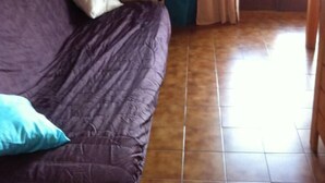 A room with a wooden ceiling, a bed with a purple bedspread and pillows, a window with blue curtains, and a tiled floor. - Apartment/ flat - Thollon les memises (Thollon-Les-Mémises)