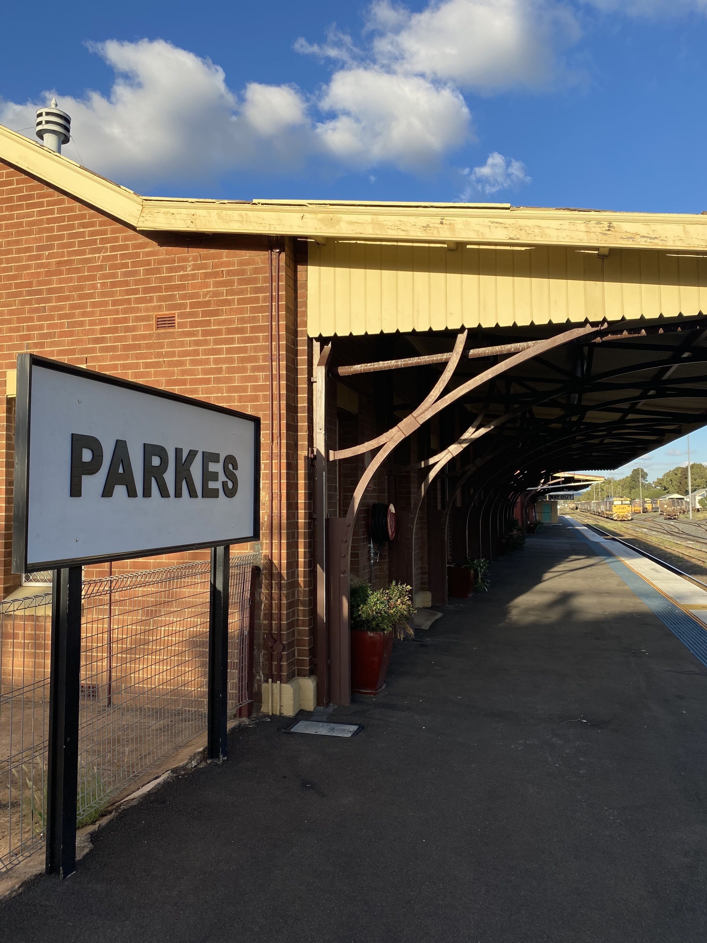En togstationsperron med et skilt, der viser "PARKES".