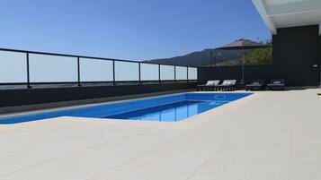 Relax by the pool surrounded by a mountainous landscape.