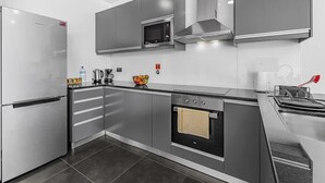A modern kitchen with a stainless steel refrigerator, a microwave, a stove, and a built-in oven. - A&M House - Luxury Holidays Home (Arco da Calheta)