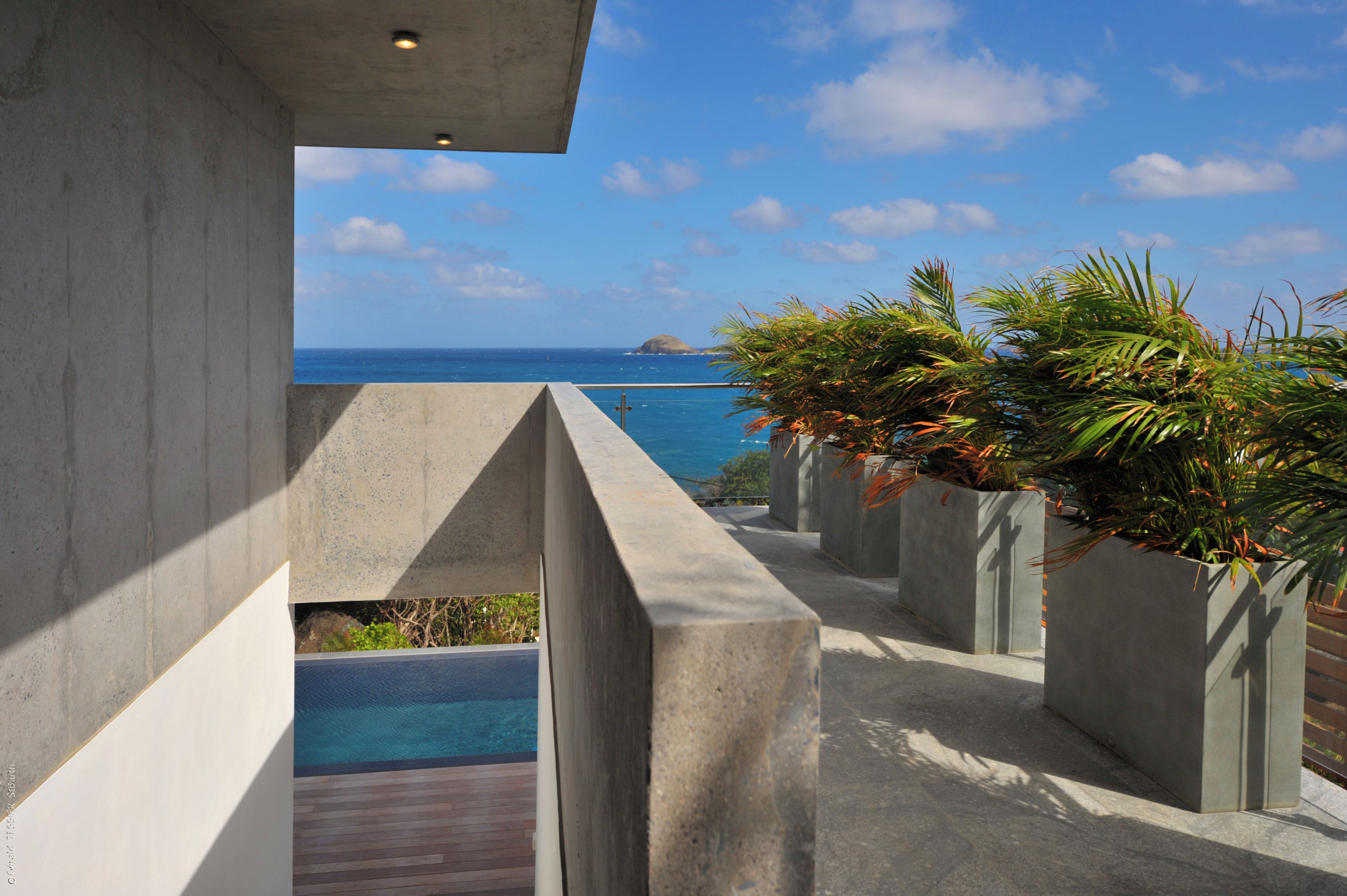 Diseño arquitectónico moderno con estructura de concreto, piscina y vista al océano.