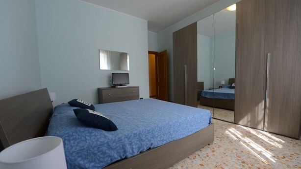 A bedroom with a bed, a dresser, a television, and a wardrobe. - Cosy apartment, near Metro A, S. Pietro and the downtown (Roma)