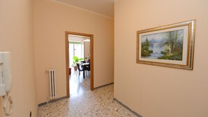 A hallway with a radiator, a telephone, and a framed painting on the wall. - Cosy apartment, near Metro A, S. Pietro and the downtown (Roma)